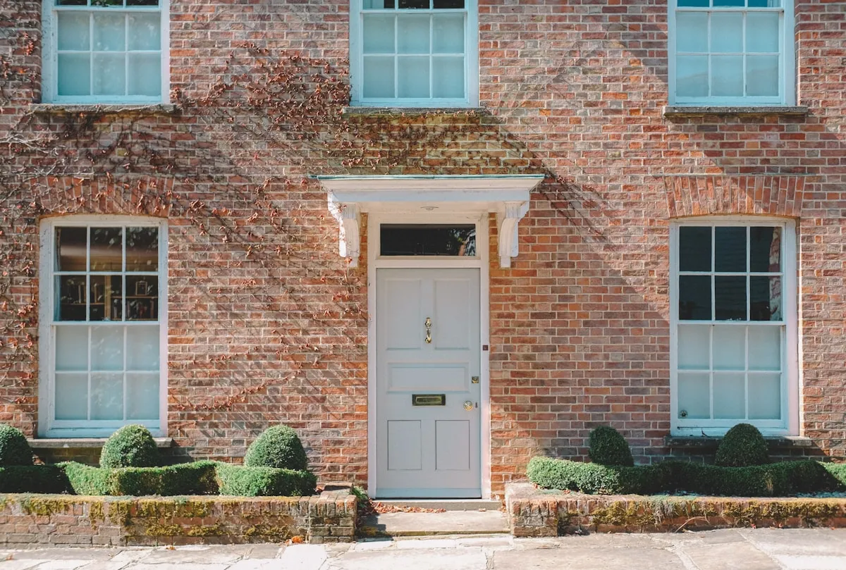 Traditional brick UK terrace with a white panelled wooden front door and fanlight